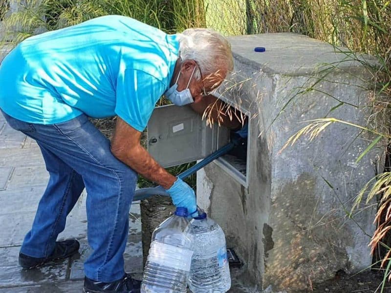 Un vecino del sector F de Almensilla recoge agua en el único grifo disponible