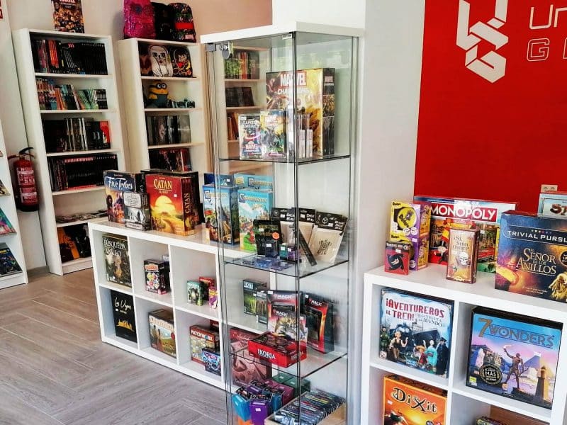 Interior de la tienda Unchained Games, especializada en juegos de mesas, cómics y merchandising.