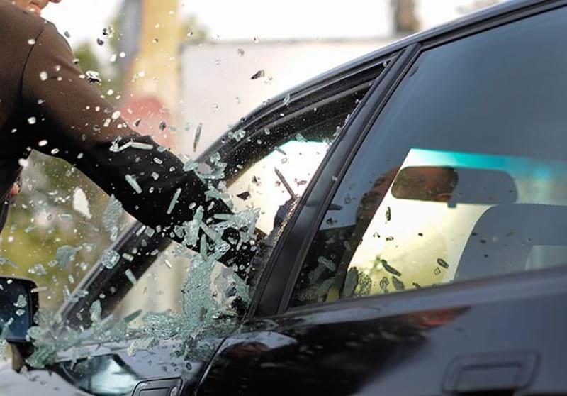 Un hombre golpea el cristal de un vehículo. Foto de Shutterstock