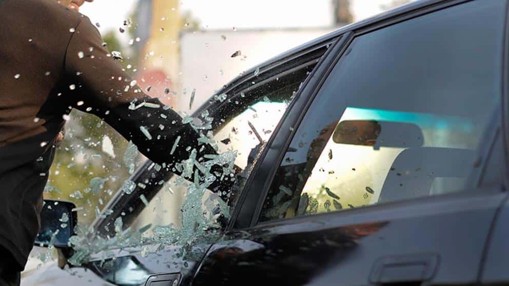 Un hombre golpea el cristal de un vehículo. Foto de Shutterstock