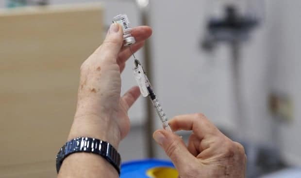 Una sanitaria prepara una vacuna para ser administrada.