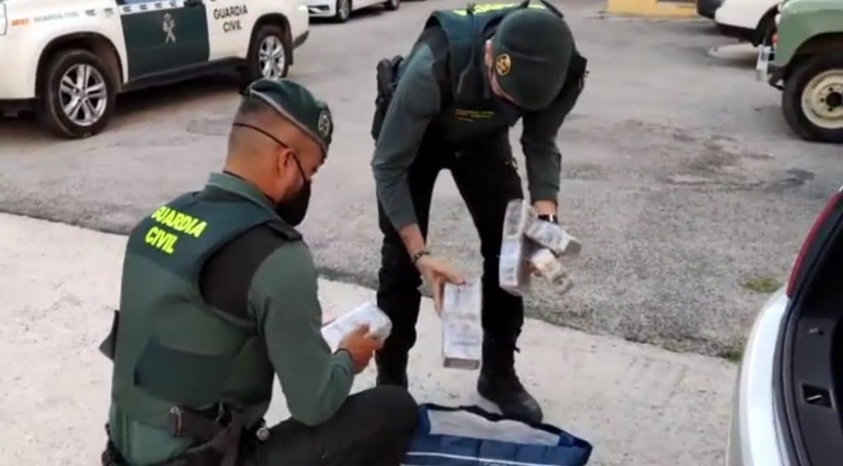 Los guardias civiles extraen de la bolsa los bloques de hachís.
