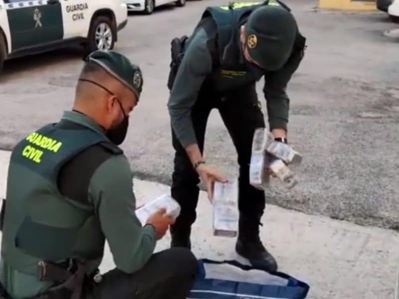 Los guardias civiles extraen de la bolsa los bloques de hachís.