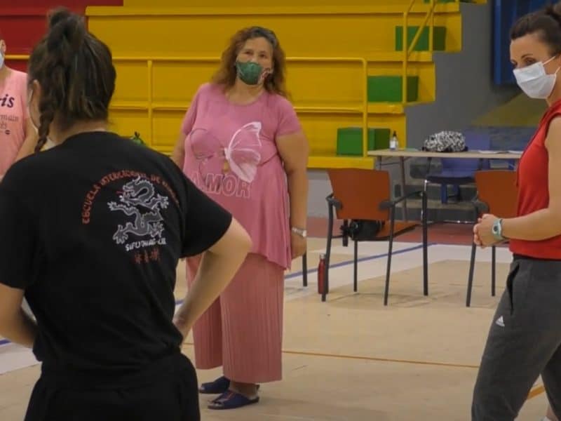 La instructora enseña movimientos a las mujeres que participan en el taller.
