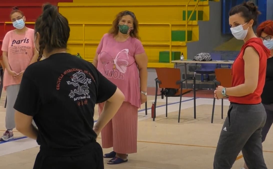 La instructora enseña movimientos a las mujeres que participan en el taller.