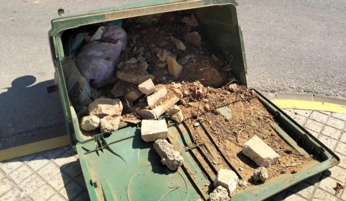 Escombros en un contendor volcado en Umbrete.