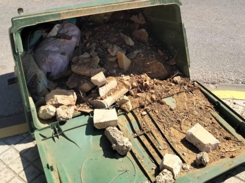 Escombros en un contendor volcado en Umbrete.