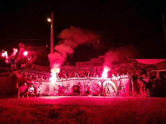 Ultras sevillistas portan banderas robadas a los ultras polacos de Slask en 2013.