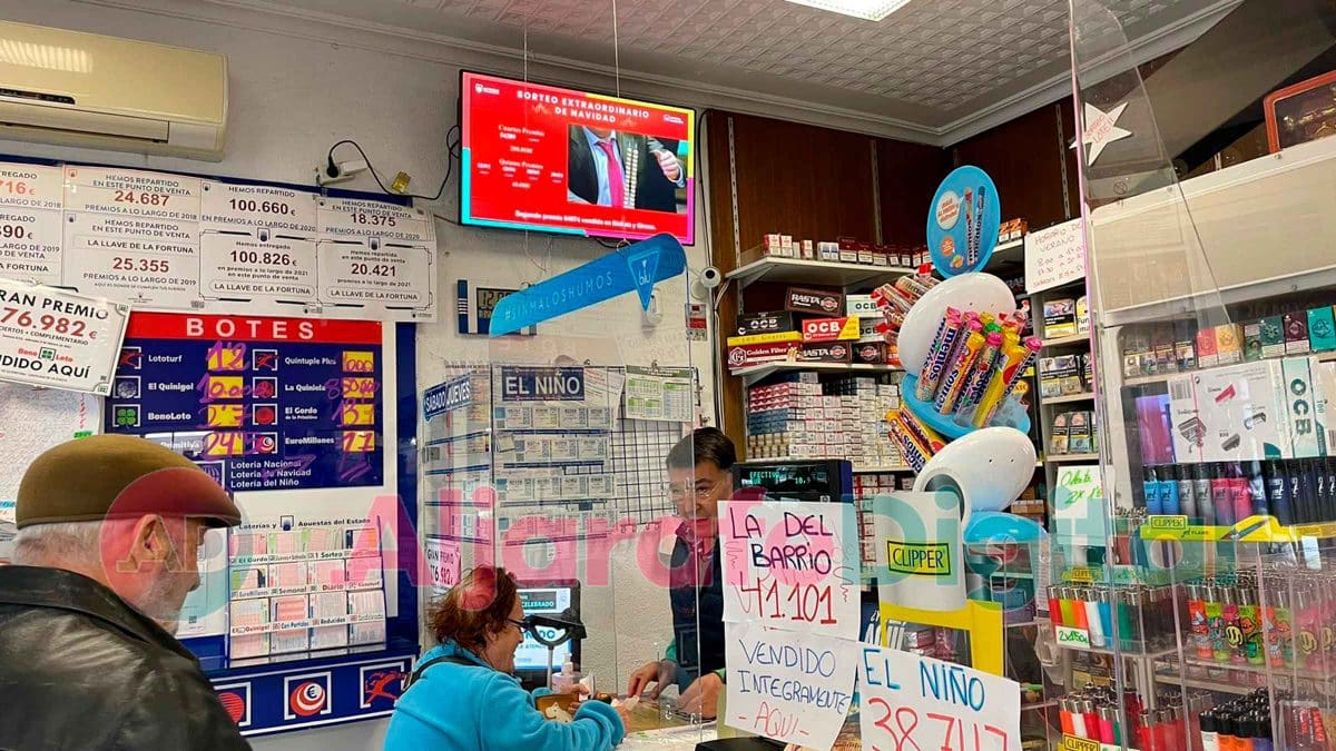 Imagen de Emilio Gómez, el lotero que ha repartido El Gordo en Nueva Sevilla atendiendo a su clientela / Clara Fajardo