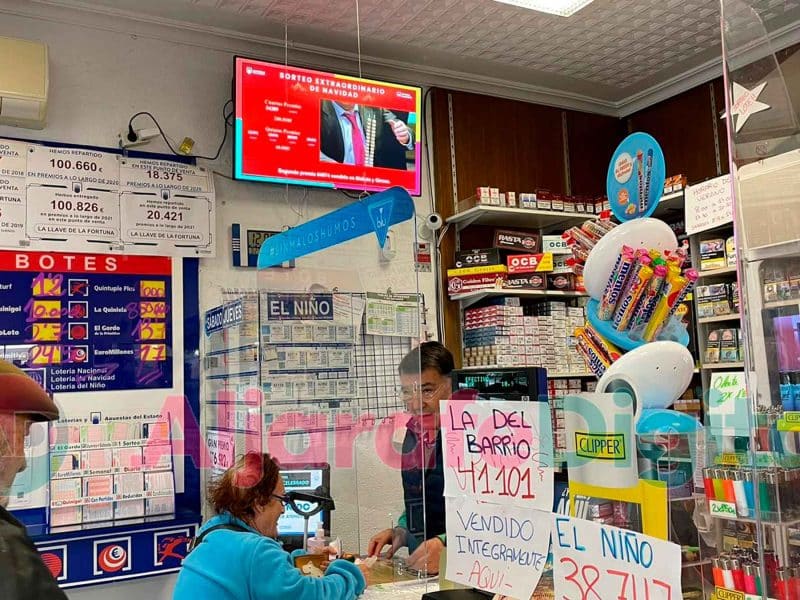 Imagen de Emilio Gómez, el lotero que ha repartido El Gordo en Nueva Sevilla atendiendo a su clientela / Clara Fajardo